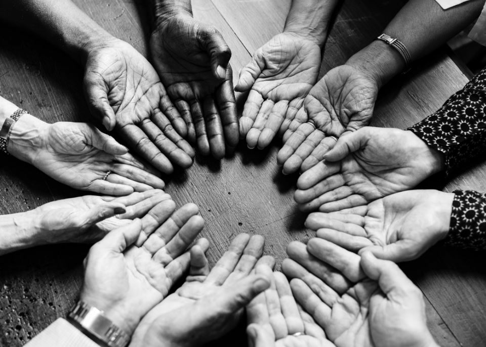 Large image of multiple hands in a circle.